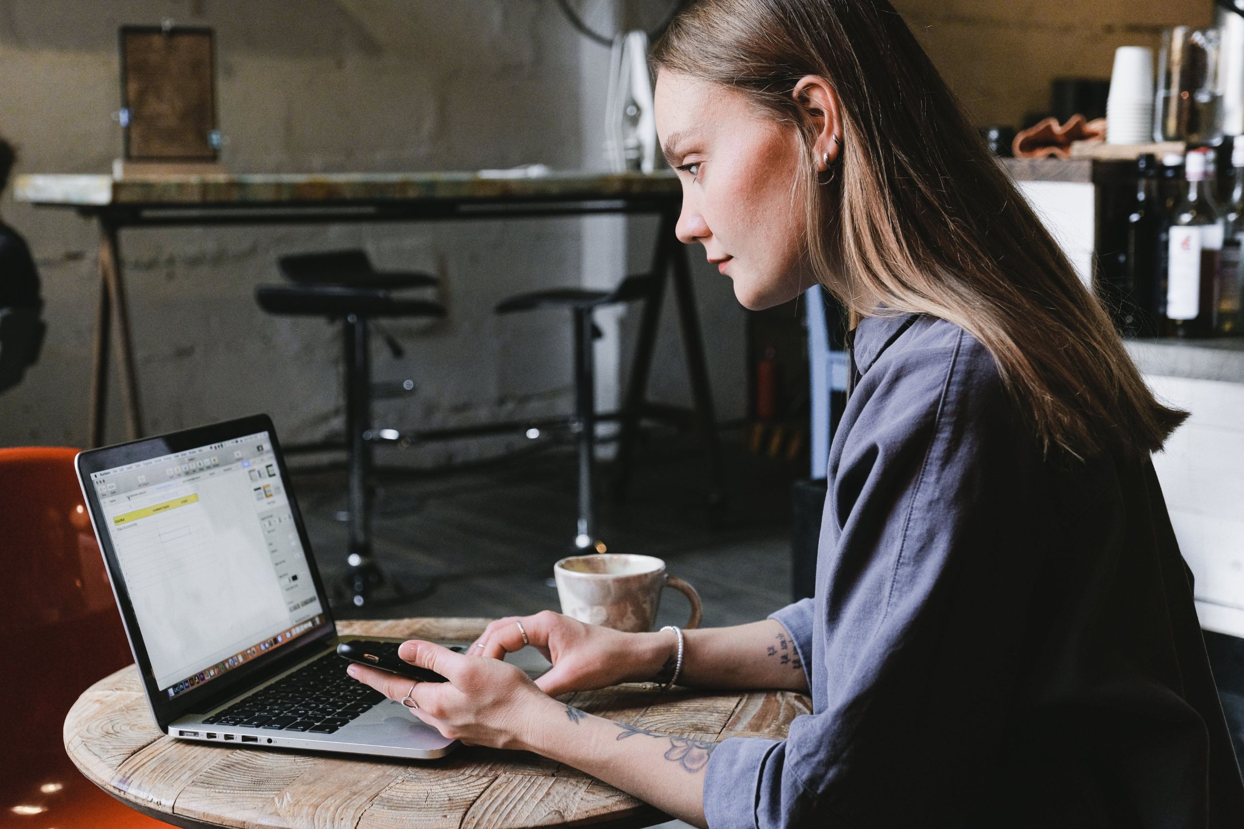 Kvinna som arbetar på en laptop på ett café