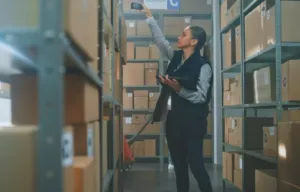 Kvinna scannar produkter på ett lager