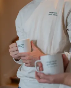 Personal från Factoringgruppen med profilkläder och kaffemuggar med länge leve goda affärer