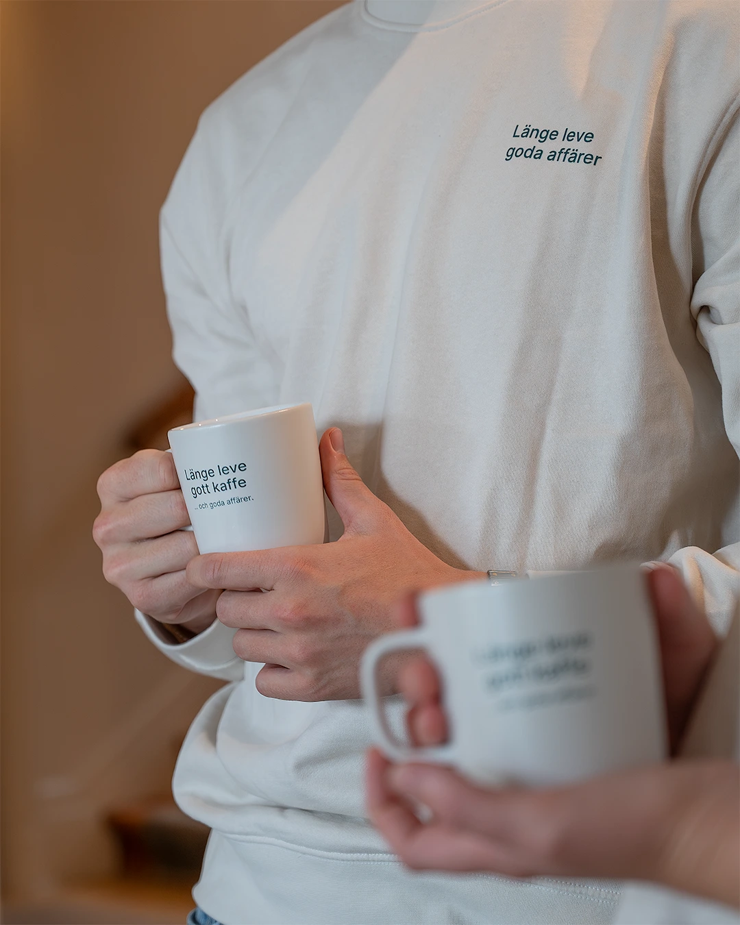 Personal från Factoringgruppen med profilkläder och kaffemuggar med länge leve goda affärer